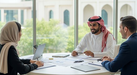 Three diverse professionals collaborate on a project, engaging in a productive discussion around a table in a modern space.