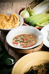 Shrimp paste chili dip, steamed rice, stir-fried morning glory with chili paste and omelet are placed on the dining table. Retro Thai style image.