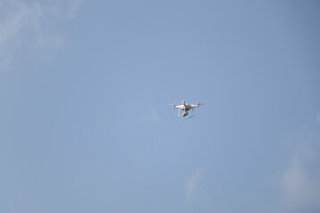 Modern quadcopter soaring through a clear blue sky