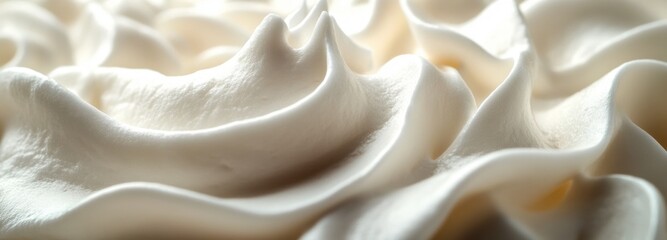 Velvety white whipped cream with soft flowing curves create a delightful texture perfect for dessert toppings
