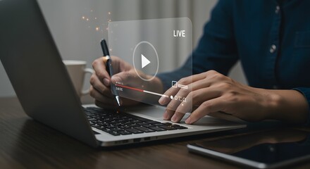 Digital Live Streaming: A person's hands work at a laptop, with a transparent live overlay superimposed over the interface, indicating an ongoing broadcast. The scene, captured in a low-angle shot.