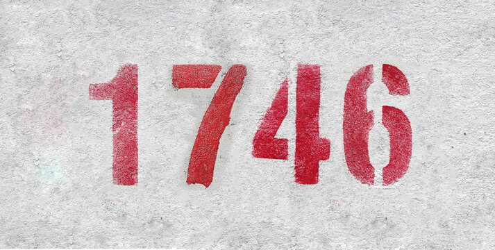 Red Number 1746 on the white wall. Spray paint.