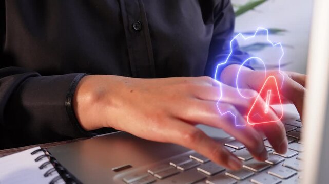 Detail of female hands typing on a laptop with a virtual, luminous icon of a gear and a Warning sign