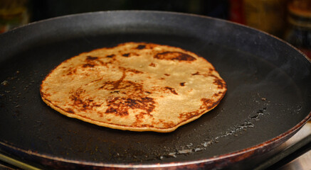 Golden Pancake Being Cooked in a Black Nonstick Pan