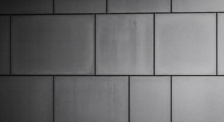 A wall of large-format, dark grey concrete tiles with visible seams, creating a minimalist, clean, and industrial architectural background.
