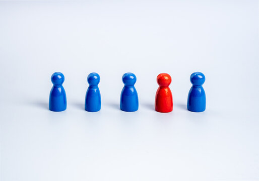 Stand out from the crowd, leadership, unique, influencer, talent people, difference concept. The red one standing different in the group of blue wooden figures, people symbols, on white background.
