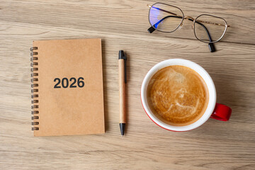 2026 notebook and coffee cup on wood table, Top view and copy space. Xmas, Happy New Year, Goals, Resolution, To do list, Strategy and Plan concept