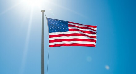 Fototapeta premium United States of American national flag with stars and stripes waving freely in the blue sky.