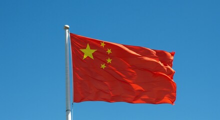 China national flag. The patriotic red national flag of China waves against a clear blue sky, a powerful emblem of the Asian republic