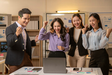A group of people are celebrating in front of a laptop