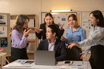 A group of people are in a meeting room with a laptop on the table