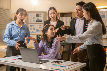A group of people are arguing in a room with a laptop on the table