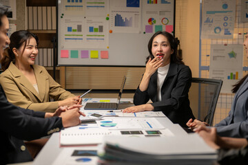 A woman is sitting at a table with other people