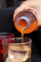 Pouring  soft drink and ice in glass