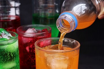 Pouring  soft drink and ice in glass