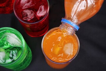 Pouring  soft drink and ice in glass