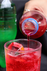 Pouring  soft drink and ice in glass