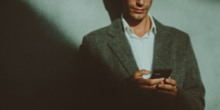 Professional businessman conducting vulnerability scan with secure mobile data icons overlay, premium corporate cybersecurity concept for modern marketing - Powered by Adobe