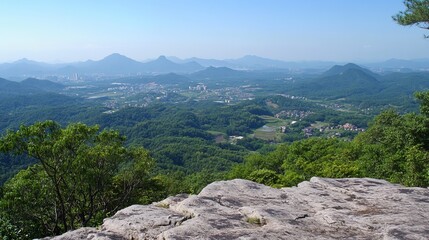 Panoramic mountain vista.  Rocky outcrop foreground. Lush valleys