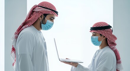 Two men in traditional Middle Eastern attire wearing face masks collaborate on a laptop, showcasing modern technology and cultural fusion.