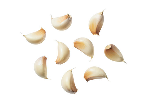 Several peeled garlic cloves scattered on a food ingredient