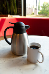 Coffee, Orange Juice and Thermos on Marble Table in Café Setting