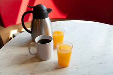 Coffee, Orange Juice and Thermos on Marble Table in Café Setting
