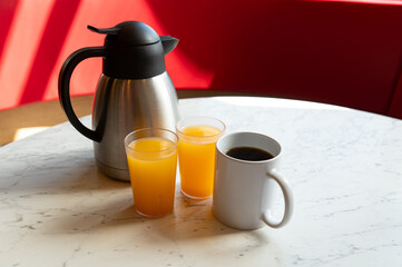 Coffee, Orange Juice and Thermos on Marble Table in Café Setting