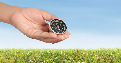 Hand holding compass symbolizing direction and navigation in an urban setting Business Concepts,...