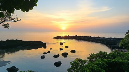 Tranquil sunset over calm ocean waters, rocky shore framed by tropical foliage