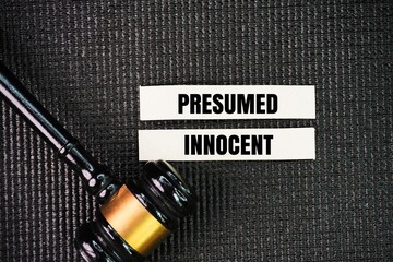 Judge's gavel and paper with the word presumed innocent. Any defendant in a criminal trial is assumed to be innocent until they have been proven guilty.