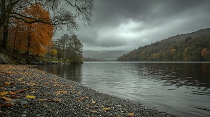 Autumn lake scene with colorful trees, dark water, and overcast sky