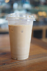 Iced coffee served in a clear cup on a wooden table