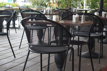 Outdoor cafe seating with empty tables and chairs in city