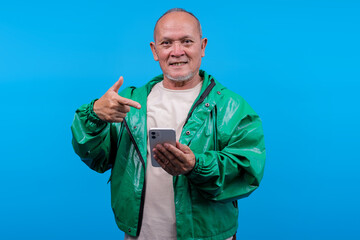 Smiling Mature Asian Man Holding Smartphone Pointing At It With Enthusiasm