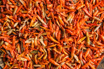 Freshly harvested chilies are sun-dried using traditional methods, then processed into products like chili powder, instant sambal, and chili extract to increase market value and farmers’ income.