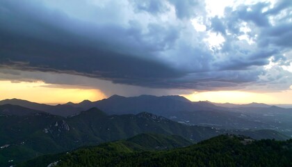 Fototapeta premium Dramatic sunset over layered mountains with a storm approaching