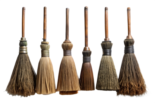 A collection of six old, rustic witch brooms made of straw and twigs, isolated on a transparent background
