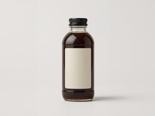 High-quality studio image of cold brew coffee in a clear glass bottle with blank paper label and black cap, isolated on white background, ideal for branding, packaging, or advertising use.