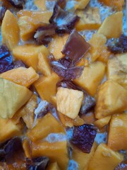 A vibrant close-up of diced mango mixed with dates, served in a creamy base. This image captures the freshness of tropical fruits, the richness of dates, and the smoothness of the creamy element.