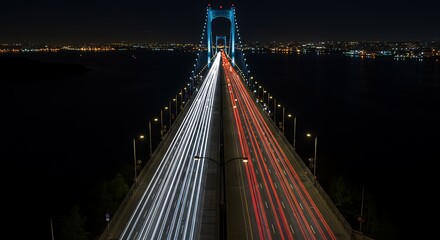 Obraz premium Long Exposure Night Bridge with Traffic Trails and City Lights in Distance