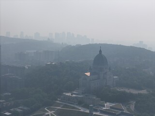 Aerial view of Saint Joseph's Oratory in Montreal under heavy smog, haze and forested hills. c.