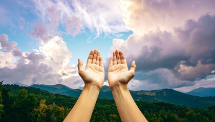 Hands raised in prayer against a dramatic mountain and sky