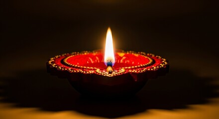 Red diya with golden trim and bright flame lamp fire