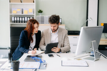 Fototapeta premium Two busy happy professional business man and woman executive leaders team using laptop working