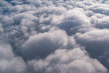 A vast sea of soft, fluffy clouds stretches endlessly below, viewed from above at high altitude, capturing the peaceful beauty and textured patterns of the sky during flight.
