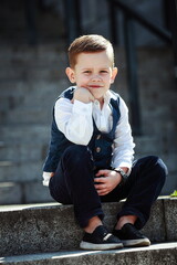 Little Boy Sitting on Steps Thinking, Dressed in Elegant Outfit
