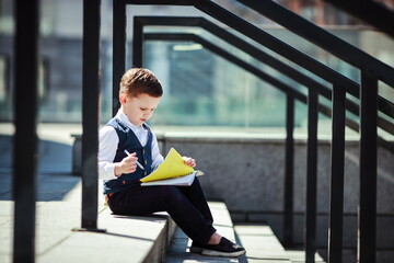 Young Boy Drawing on the Steps Outdoors in Bright Light