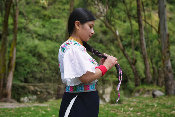 Indigenous colombian woman braiding her hair in a peaceful natural setting