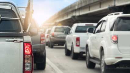 Rear side of pickup white car with pickup truck fencing. And turn on brake light. Traffic is congested with many cars queuing up. Background of concrete bridgeunder blue sky. © thongchainak